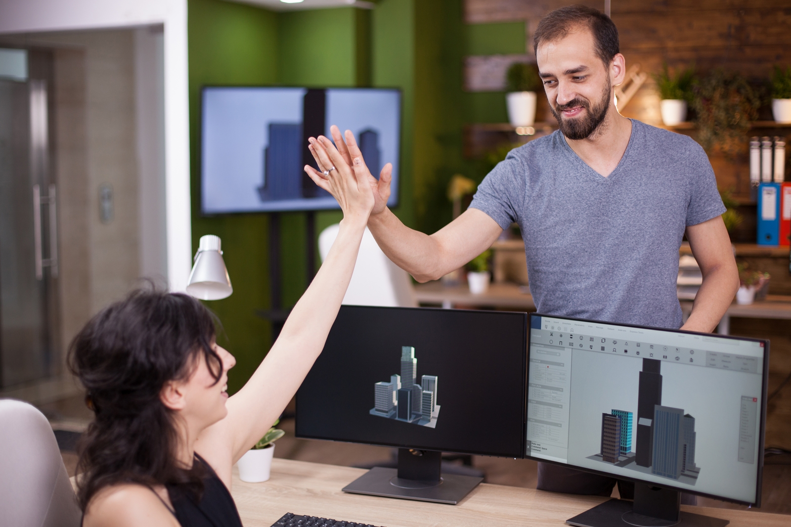 Frau und Mann beim Handschlag am PC-Arbeitsplatz